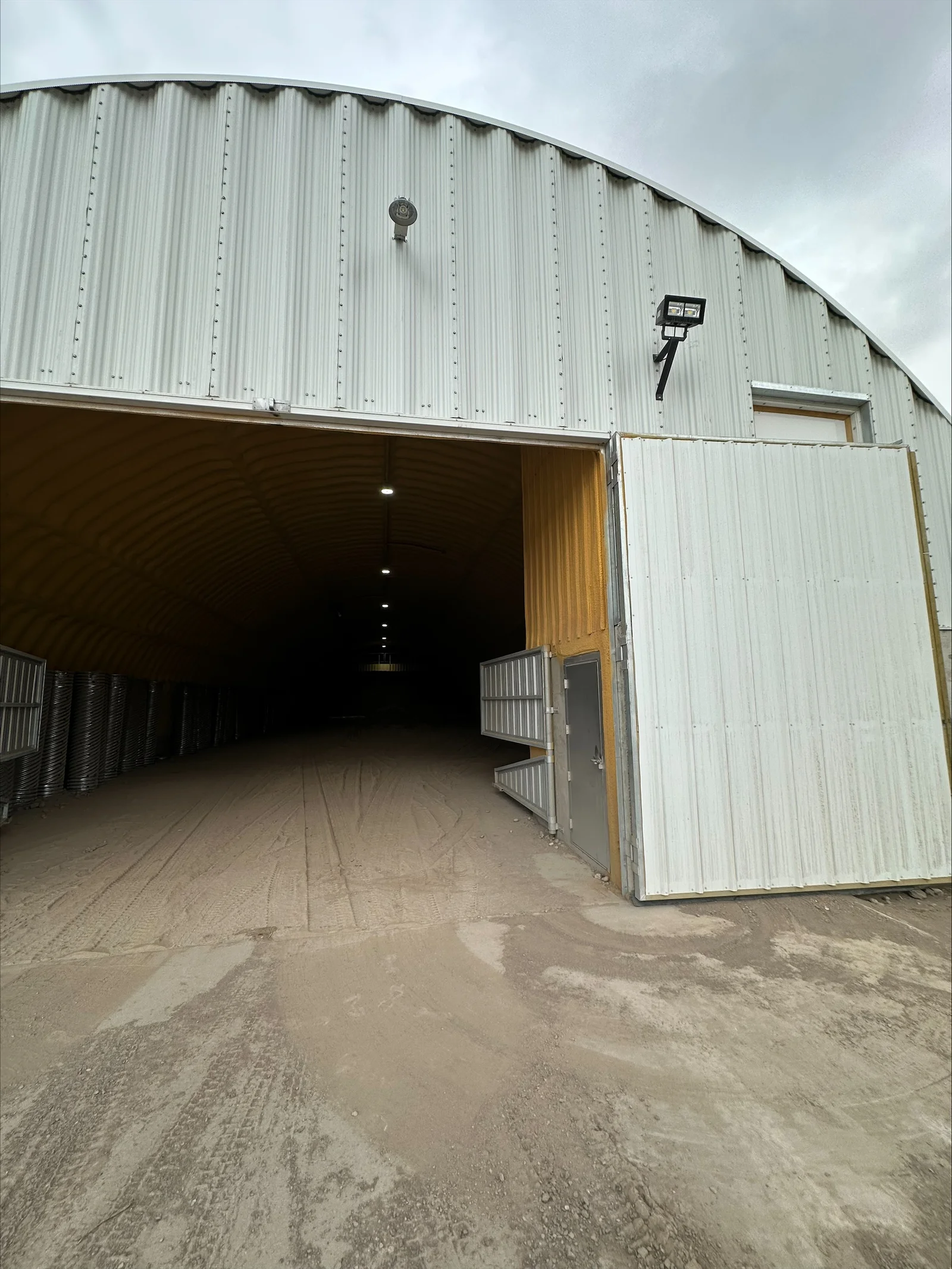 Metal agricultural building interior with recessed ceiling lights and exterior security light fixture installed