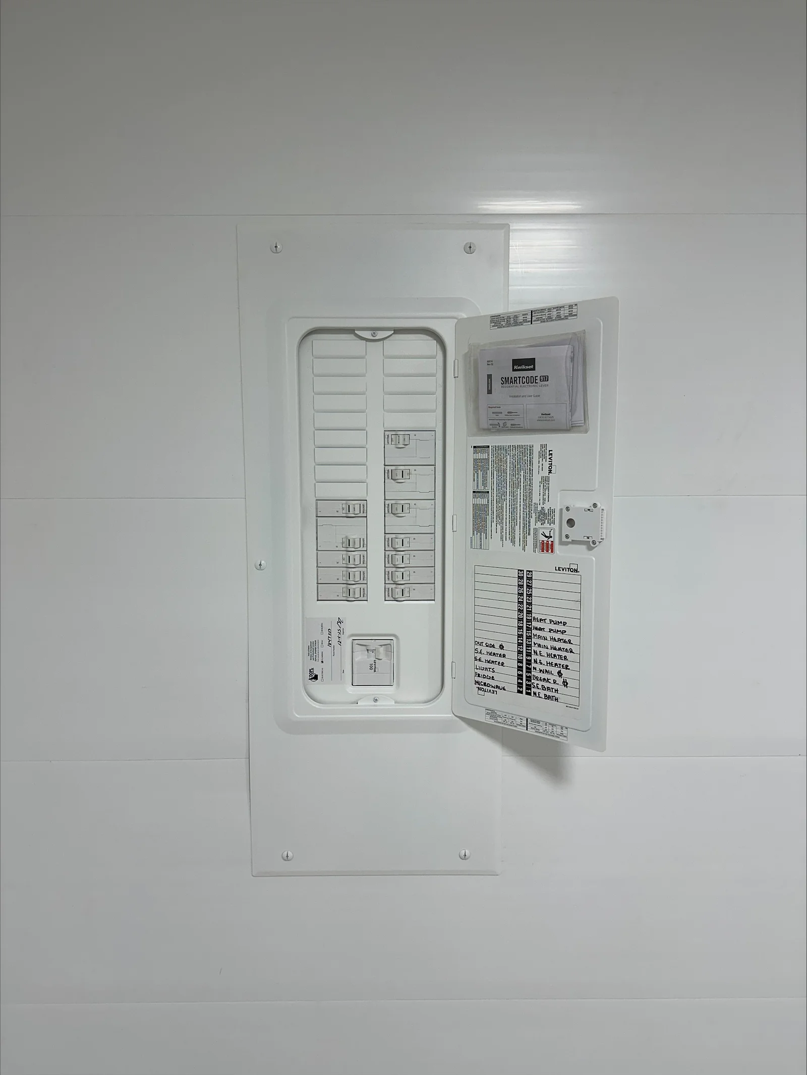Smart electrical panel with circuit breakers, SmartCode hub, and organized wiring in white wall-mounted enclosure