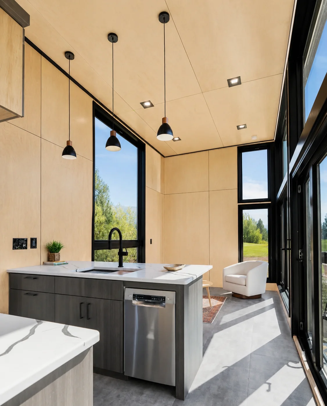 Modern kitchen with recessed and pendant lighting, black cabinetry, white countertops, and integrated electrical systems
