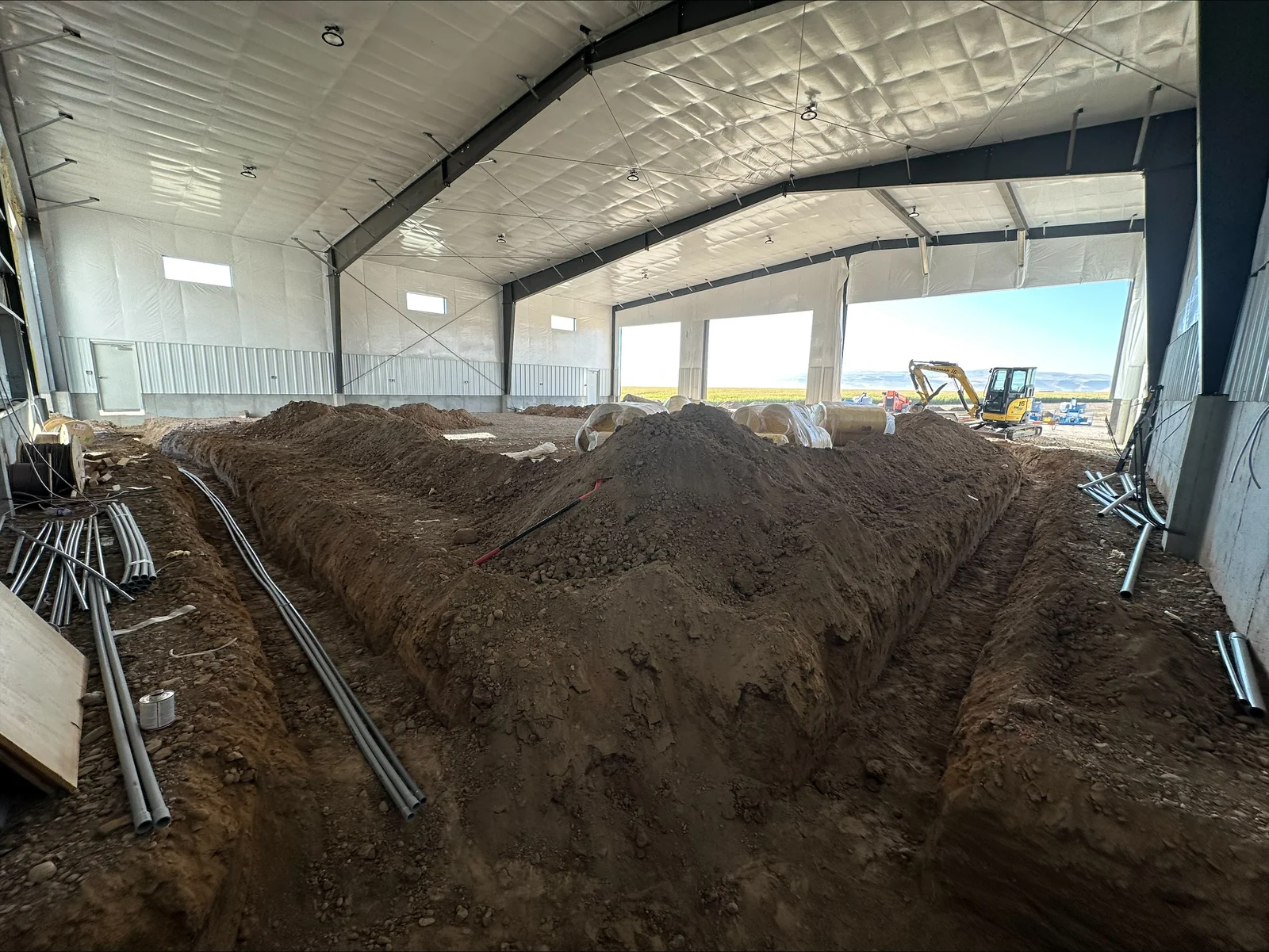 Electrical conduit and rough-in wiring installed in agricultural building interior with metal structure